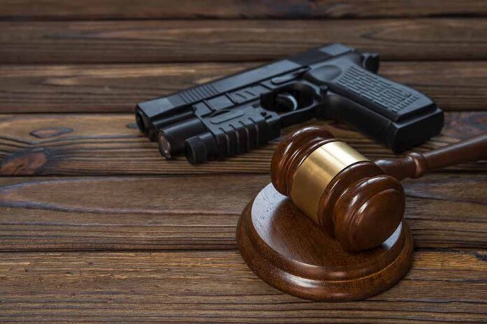 Gavel and gun on wooden table.