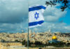 Israeli flag flying over Jerusalem skyline with Dome of Rock.