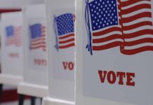 Voting booths with American flags and Vote signs.