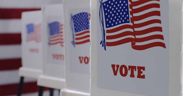 Voting booths with American flags and Vote signs.