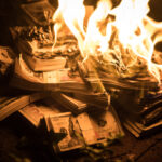 Burning stack of money in flames