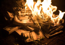 Burning stack of money in flames