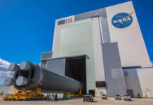 NASA building with rocket booster being transported outside.