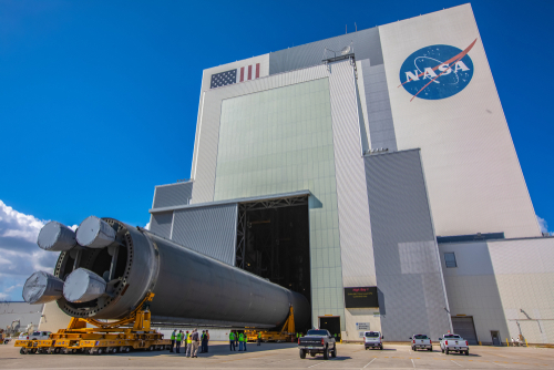 NASA building with rocket booster being transported outside.