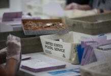 Workers handling mail-in ballots at a postal service.