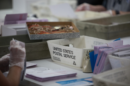 Workers handling mail-in ballots at a postal service.