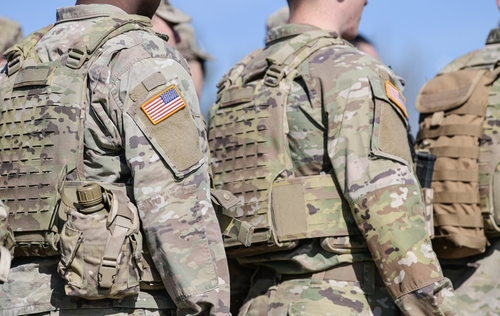 Soldiers in camouflage uniforms with American flag patches.