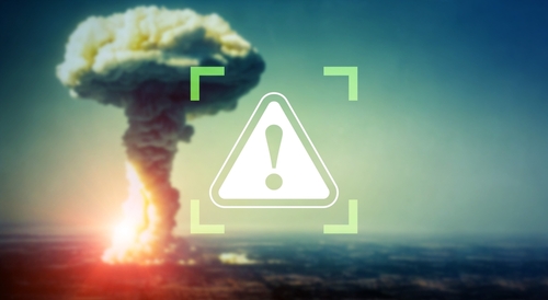 Mushroom cloud explosion with a warning symbol overlay.