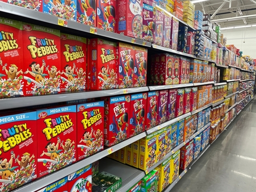 Cereal aisle with Fruity Pebbles and other cereal boxes.