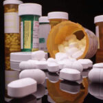 Assorted prescription pill bottles and tablets scattered.