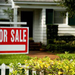 House with a For Sale sign in front.