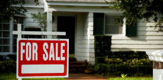 House with a For Sale sign in front.
