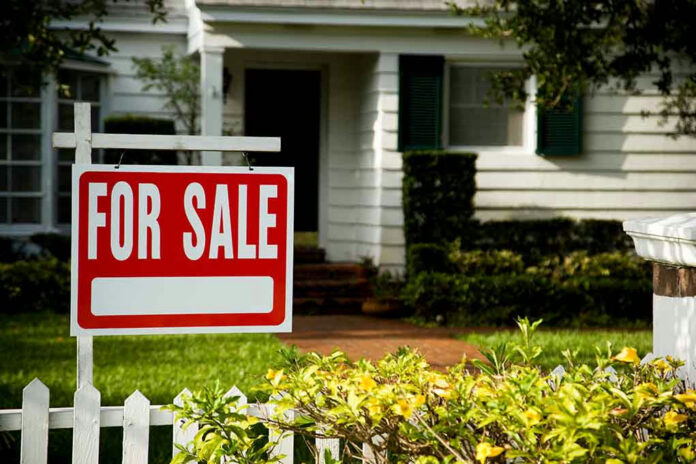 House with a For Sale sign in front.