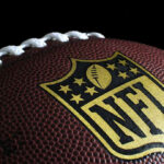 Close-up of football with NFL logo.
