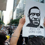 Person holding Justice for George Floyd sign at protest.