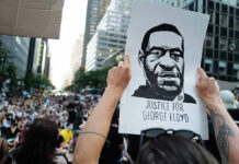 Person holding Justice for George Floyd sign at protest.