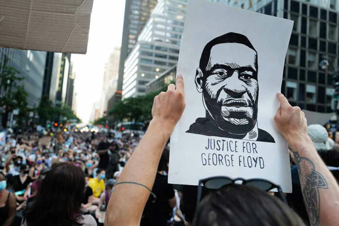Person holding Justice for George Floyd sign at protest.