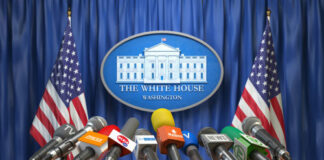 Press briefing podium with many microphones at a government venue