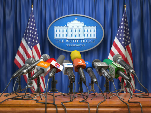Press briefing podium with many microphones at a government venue