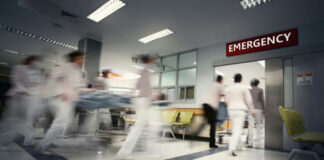 Medical staff rushing patient on stretcher in emergency room.