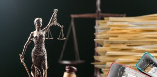 A statue of Lady Justice holding scales, surrounded by legal documents and a gavel