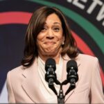 Female speaker smiling at a podium with microphones