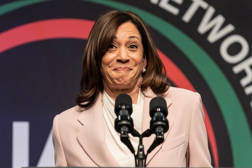 Female speaker smiling at a podium with microphones