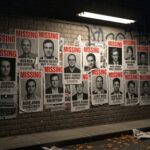 Wall covered with missing persons posters in an urban setting