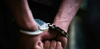 Hands in handcuffs behind back.