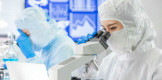 Scientists examining samples under microscopes in a laboratory.