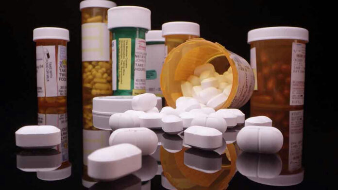 1753523942 Assorted prescription pill bottles and tablets scattered.