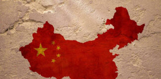 Chinas map with flag painted on textured wall.
