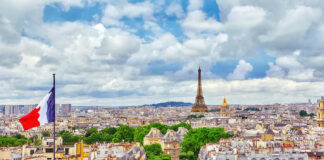 Eiffel Tower view with French flag and cityscape.