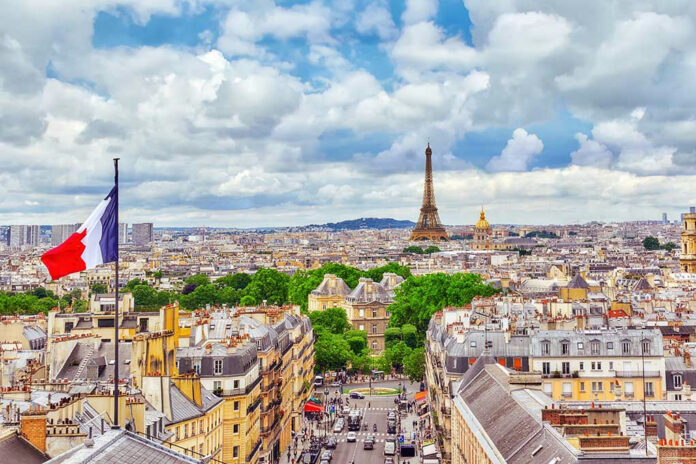 534148672 Eiffel Tower view with French flag and cityscape.