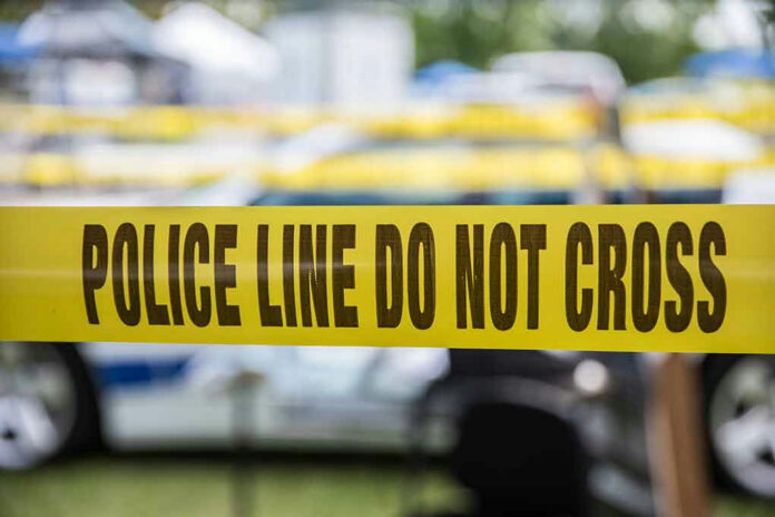 627591236-1 Yellow police tape that says, Police Line Do Not Cross.