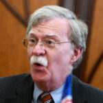 Bolton Hammered Trump on Docs — Now He’s the One Guilty Judges bench in an empty courtroom, scales emblem above.