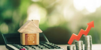 Toy house, calculator, coins, and red upward arrow.