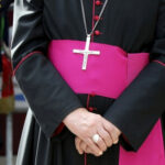 Bishop: Pride Slogans Offensive, But Marchers Must Be Respected Close-up of a cleric with cross necklace.