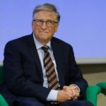 Power Circles Panic Over Gates Hearing A man in a suit sitting on a green chair during a conference