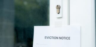 An eviction notice posted on a door with a keyhole visible