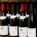 Trump Targets Macron’s Wine Weak Spot Transportation modalities: ship, truck, cargo containers, airplane, city backdrop.