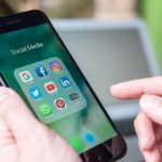 Italy Slams Kid-Hooking Algorithms Person holding smartphone with social media app folder open