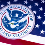 Round-the-Clock Deportations? DHS Moves US Homeland Security emblem over American flag