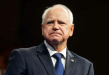 Deported Anyway: Trump Team Overrules Walz Man in suit with a U.S. flag pin.