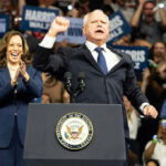 Pardon Bombshell Shields Deportation Target Two people at a political rally on stage.