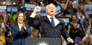 Two people at a political rally on stage.