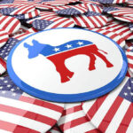 Endorsement Lie? Black Leaders Revolt Democratic donkey symbol button among American flag buttons.