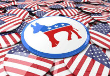 Endorsement Lie? Black Leaders Revolt Democratic donkey symbol button among American flag buttons.