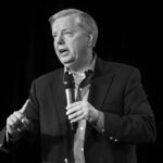 Sudden Loss Tightens Trump’s Majority Man speaking into a microphone on stage