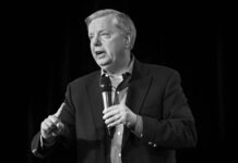 Sudden Loss Tightens Trump’s Majority Man speaking into a microphone on stage